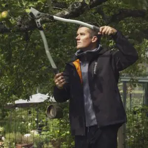 a man using loppers to cut a branch