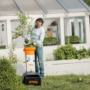 a man feeding branches into the STIHL GHE 105 Electric Chipper Shredder