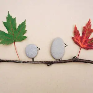 artwork featuring 2 leaves and 2 pebbles on a twig