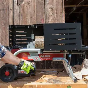a man using a small horizontal firewood splitter to cut a log