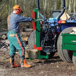 a man in a hard hat using a tractor mounted log splitter
