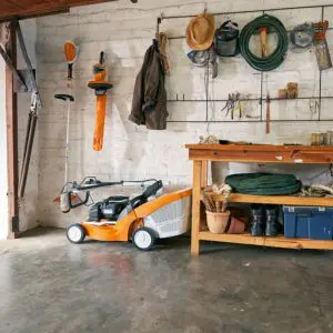 a lawnmower next to a workbench in a shed