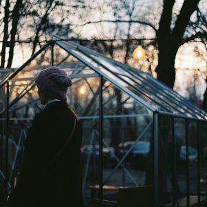 a woman outside a greenhouse in winter