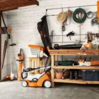 a wide range of STIHL tools on and around a workbench, within a garage