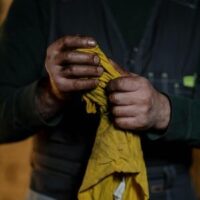 a man holding a yellow, oily cloth