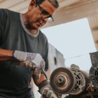 a man using a grinder to remove rust from a metal tool