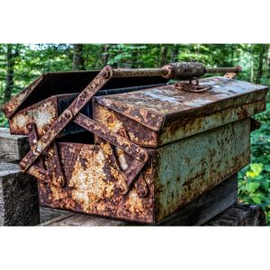 a rusty tool box sat on a bench