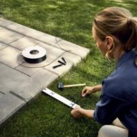 a woman installing a robotic mower's perimeter wire