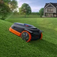 a Segway Navimow X3 Series robotic mower climbing a lawn's incline