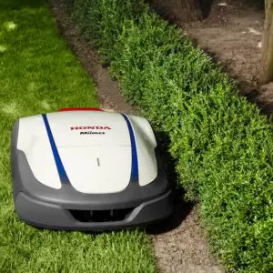 a Honda Miimo robotic lawn mower cutting the edge of a lawn