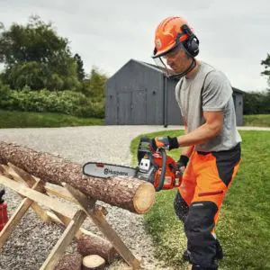 a man in a hardhat, cutting the end off a log, using a Husqvarna 450 II Chainsaw