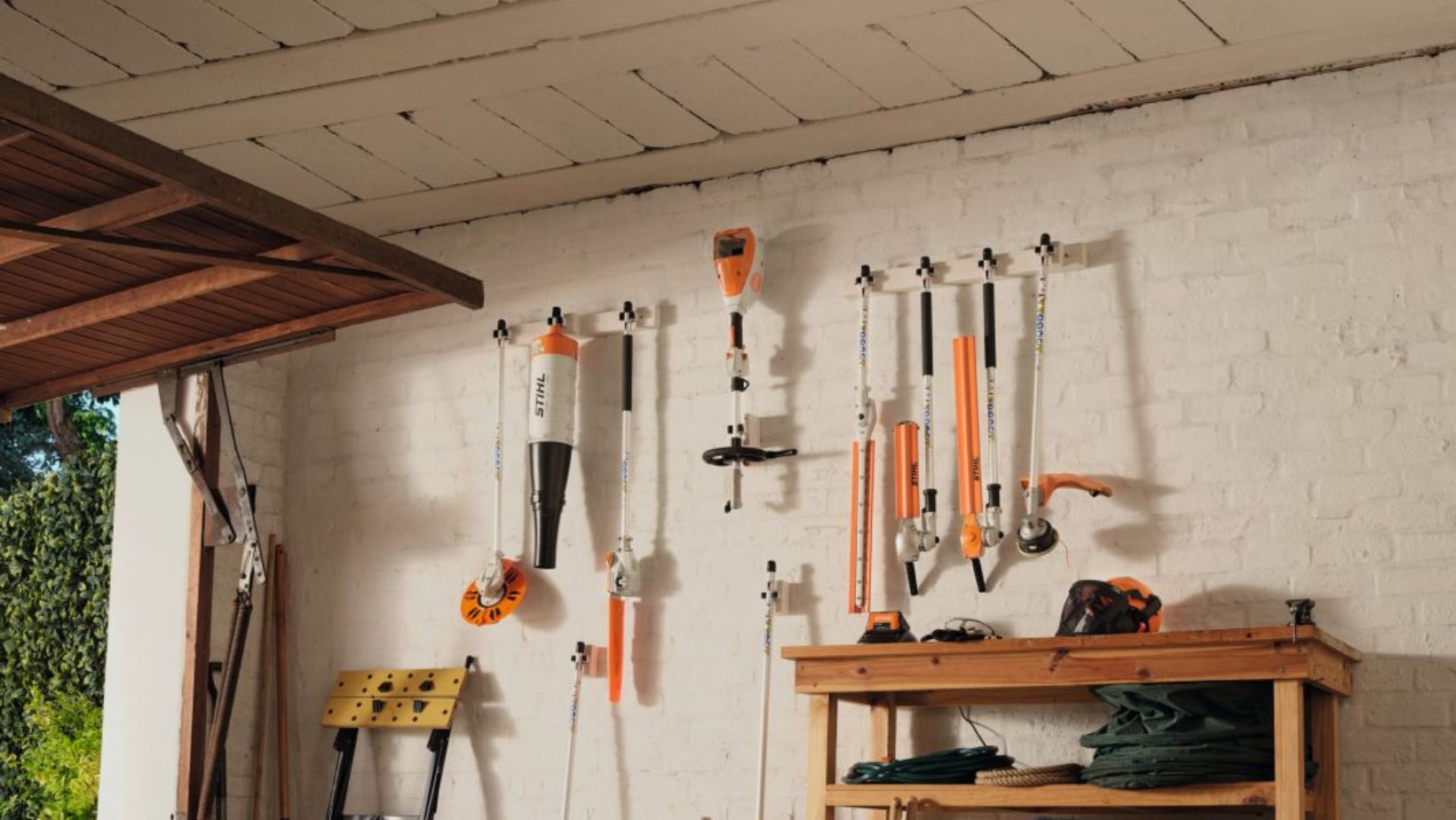 a STIHL KMA 80 R Cordless KombiMotor and set of Kombi tools, hanging on a garage wall