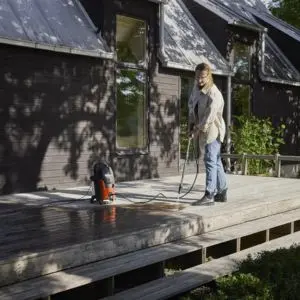 a man cleaning wooden decking with a pressure washer