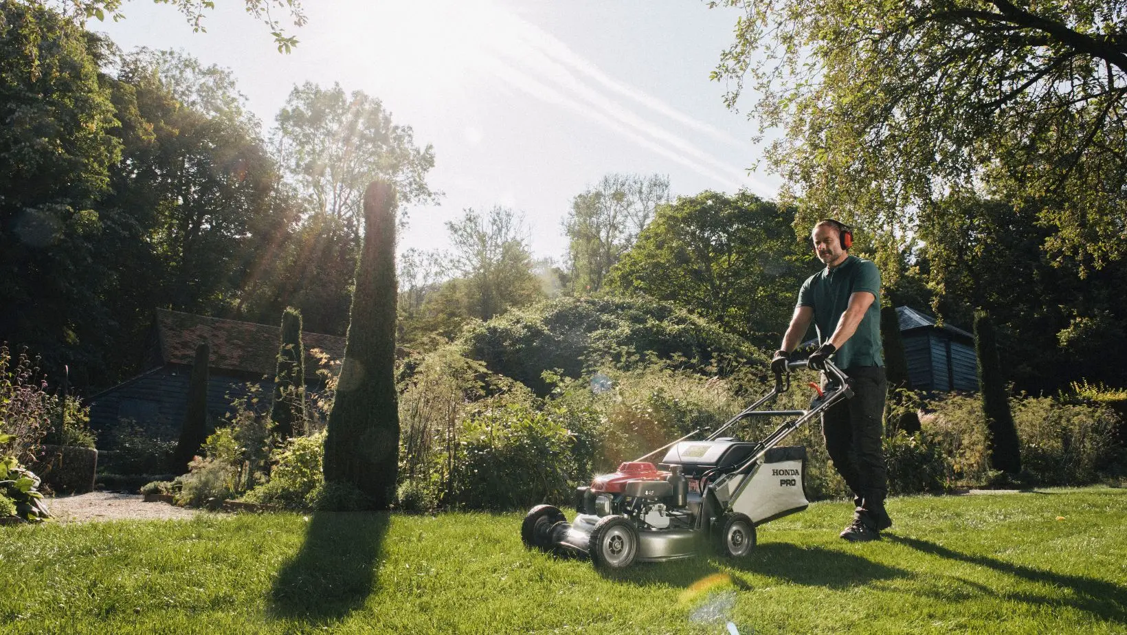 a man using a mulching mower in the garden