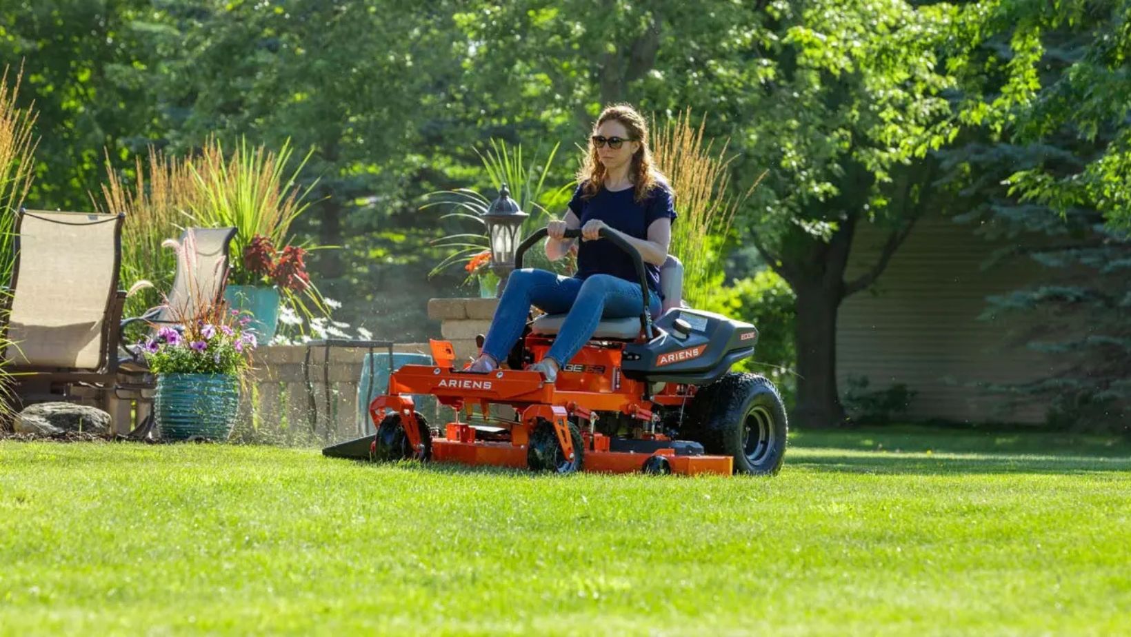 a woman using the Ariens Edge 42 Zero Turn Mower to mow a lawn