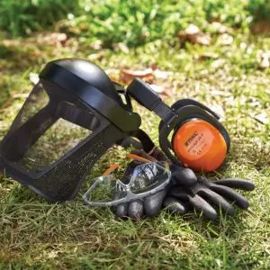 a visor, safety glasses, gloves and orange STIHL ear defenders sat on a patch of grass