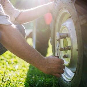a man tightening a nut on a tractor wheel