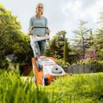 a woman mowing a lawn with a STIHL lawnmower