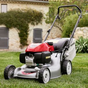 a Honda petrol mower on a lawn, outside a house