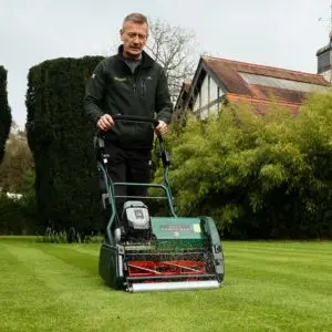 a man cutting and striping a lawn using the Allett Cambridge 43 Cylinder Lawnmower
