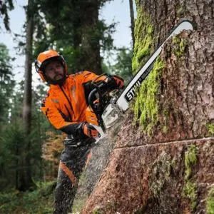 a man in full PPE, using a STIHL MS 500i Petrol Chainsaw to fell a tree