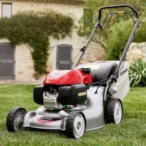 the Honda HRG466 Lawnmower on a lawn, outside a house