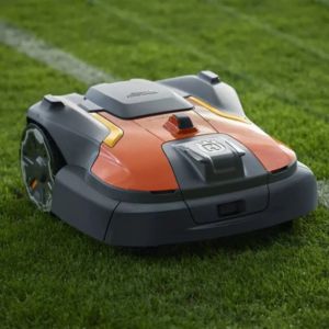 a close up of the Husqvarna Automower® 580 EPOS® Robotic Mower next to a white line on a sports pitch