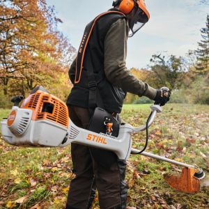 a man wearing an orange helmet, operating the STIHL FS 461 C-EM L Clearing Saw in a field