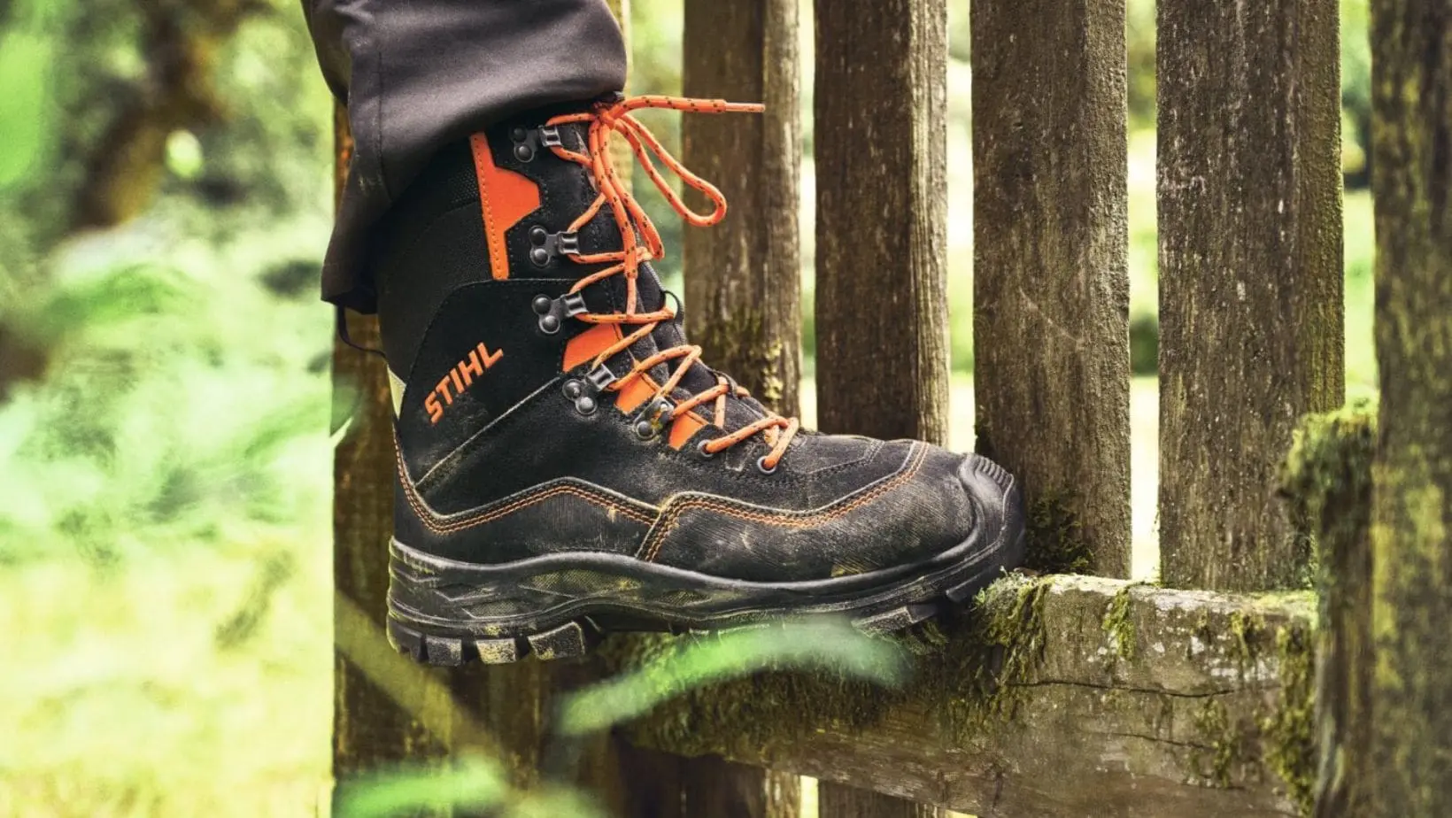 someone wearing STIHL FUNCTION Active leather chainsaw boots, with a close up of one boot resting on a wooden slat