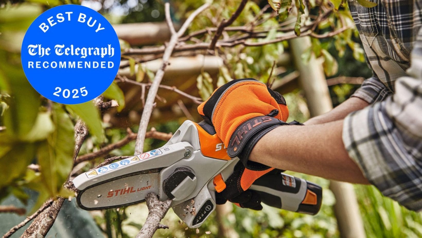 Someone using the STIHL GTA 26 Cordless Pruner to cut a tree branch, with a circular blue and white sign in the top left hand corner of the image explaining that this product is a Telegraph 'Best Buy' for 2025
