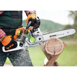 someone using the STIHL MS 231 Petrol Chainsaw to cut through a small log, which is positioned on a wooden saw horse