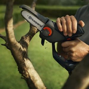 a man using the Husqvarna Aspire™ P5-P4A Pruning Saw to cut a tree branch