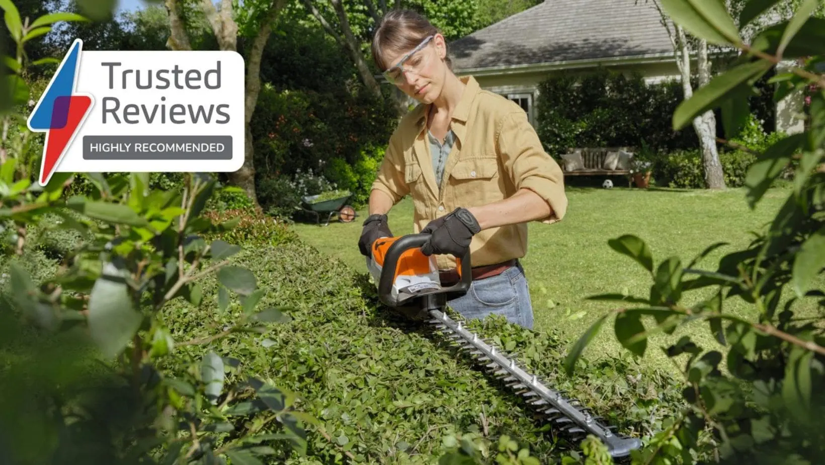 STIHL HSA 60 Cordless Hedge Trimmer-min a woman using the STIHL HSA 60 Cordless Hedge Trimmer to shape the top of a hedge, with a sign saying 'Trusted Reviews Highly Recommended' in the top left-hand corner of the image
