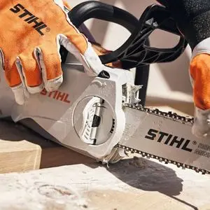 a close up of someone wearing STIHL-branded gloves, removing the guide bar from a STIHL MSA 200 Cordless Chainsaw