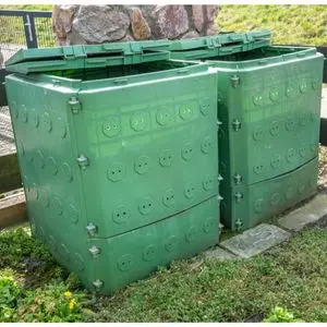 2 large, green compost bins in a garden