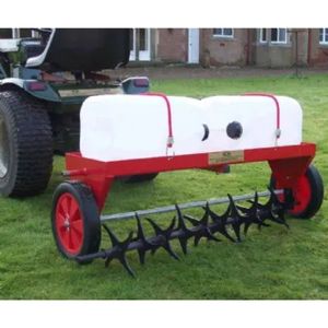 the SCH HGA Aerator Attachment being towed across a lawn by a riding mower