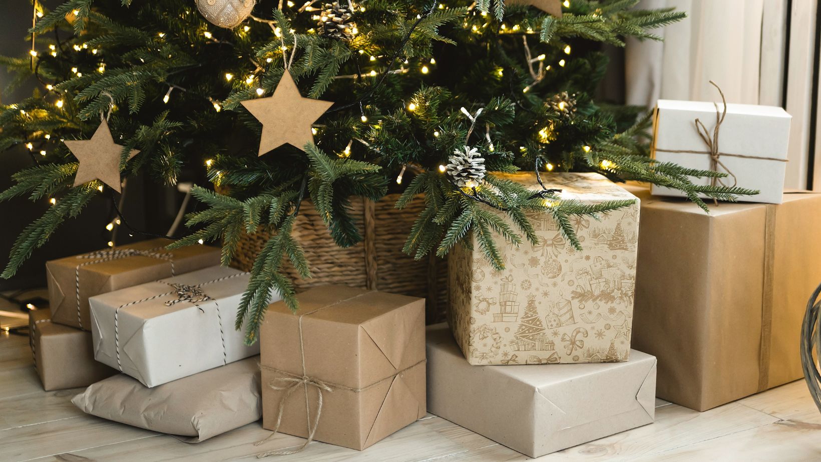 Christmas presents in an assortment of gold, brown and cream wrapping paper, underneath a Christmas tree