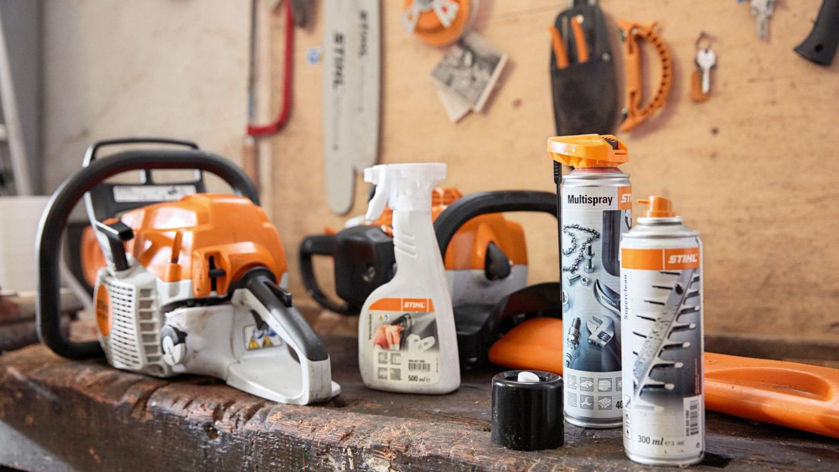 a STIHL chainsaw and selection of chainsaw cleaning and maintenance products on a workshop bench