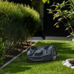 the Husqvarna Automower® 305E NERA wired robot mower travelling between borders on a lawn
