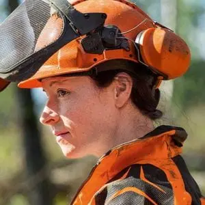 a close up of a woman wearing orange and black chainsaw PPE