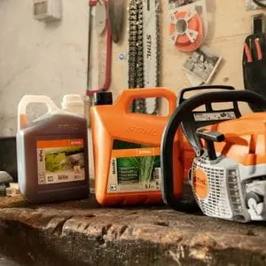 2 bottles of fuel and a STIHL petrol chainsaw on a workbench