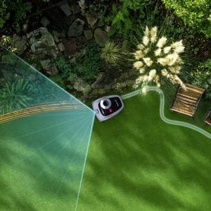 a Segway Navimow RTK robot mower navigating borders, a rockery and outdoor seating in a complex garden