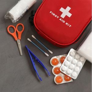 a red first aid kit, including scissors, tweezers, cotton buds, pain killers, and dressing