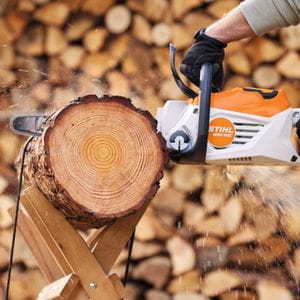someone using a STIHL MSA 80 Cordless Chainsaw with semi chisel chain to cut small pieces of firewood