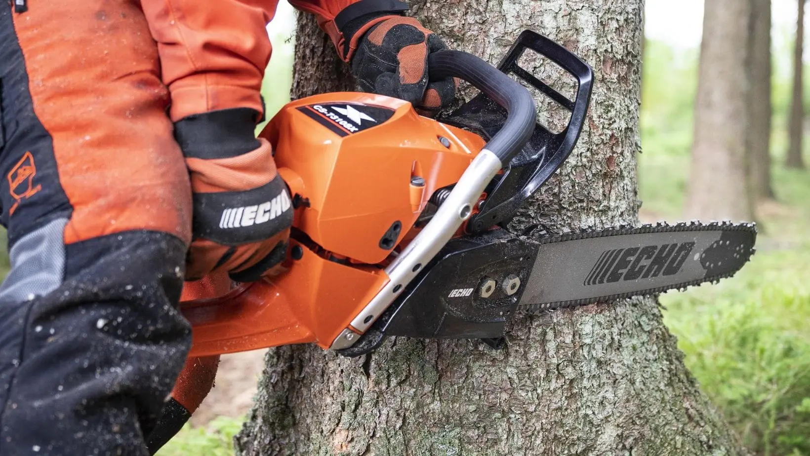 a close up of someone wearing orange chainsaw PPE, using the ECHO CS-7310SX Chainsaw to fell a tree