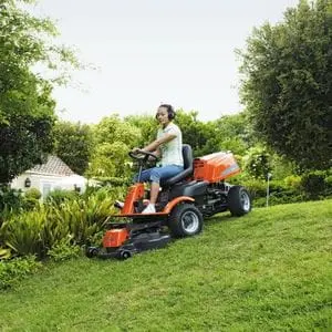 a woman driving a Husqvarna out-front ride-on mower down a steep lawn