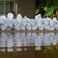 white sandbags acting as a barrier to protect a house from floodwater