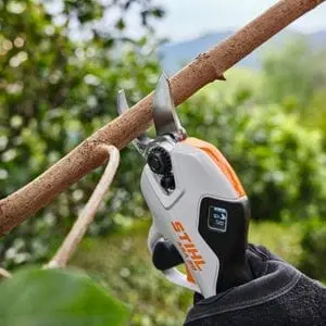 a close up of someone using the STIHL ASA 20 Cordless Secateurs to prune a tree branch