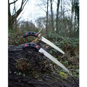 2 Silky Gomtaro saws resting above a fallen log in a forest