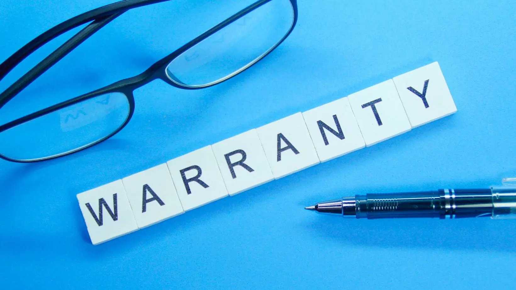main warranty (1) scrabble-type white squares spelling the word 'warranty', a pair of glasses and a pen, all against a blue background